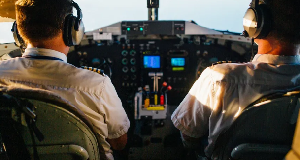 Twee piloten met headsets in de cockpit van een vliegtuig