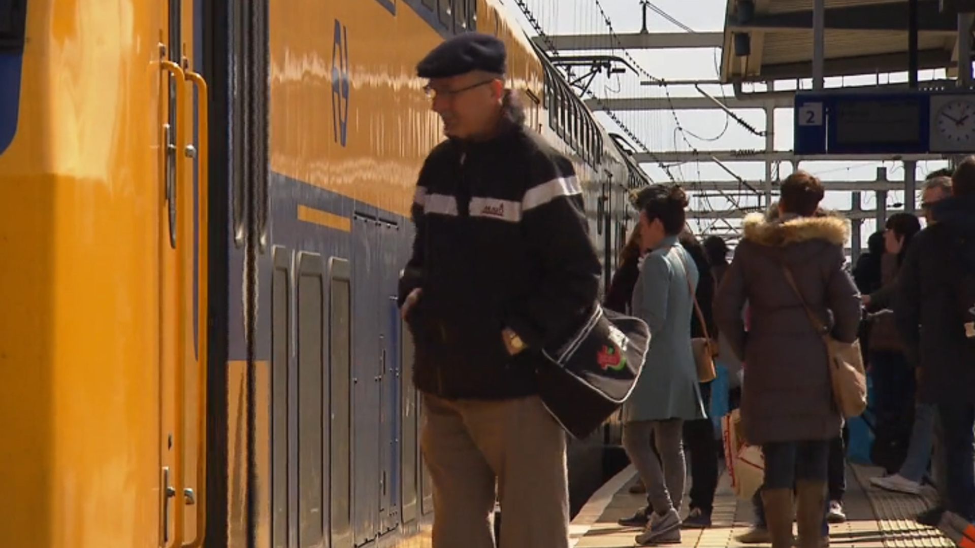 Reizigers stappen op het perron in een trein
