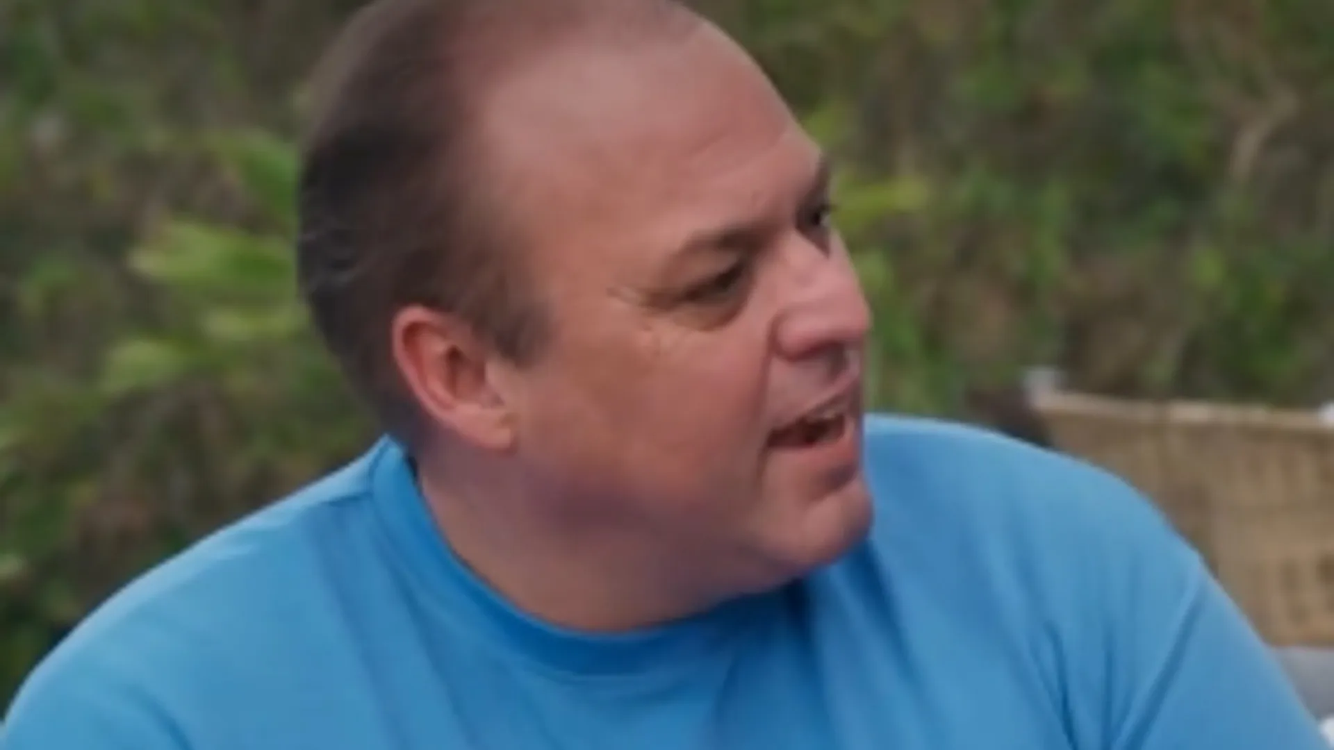 Frans Bauer in een lichtblauw overhemd tijdens een gesprek buiten