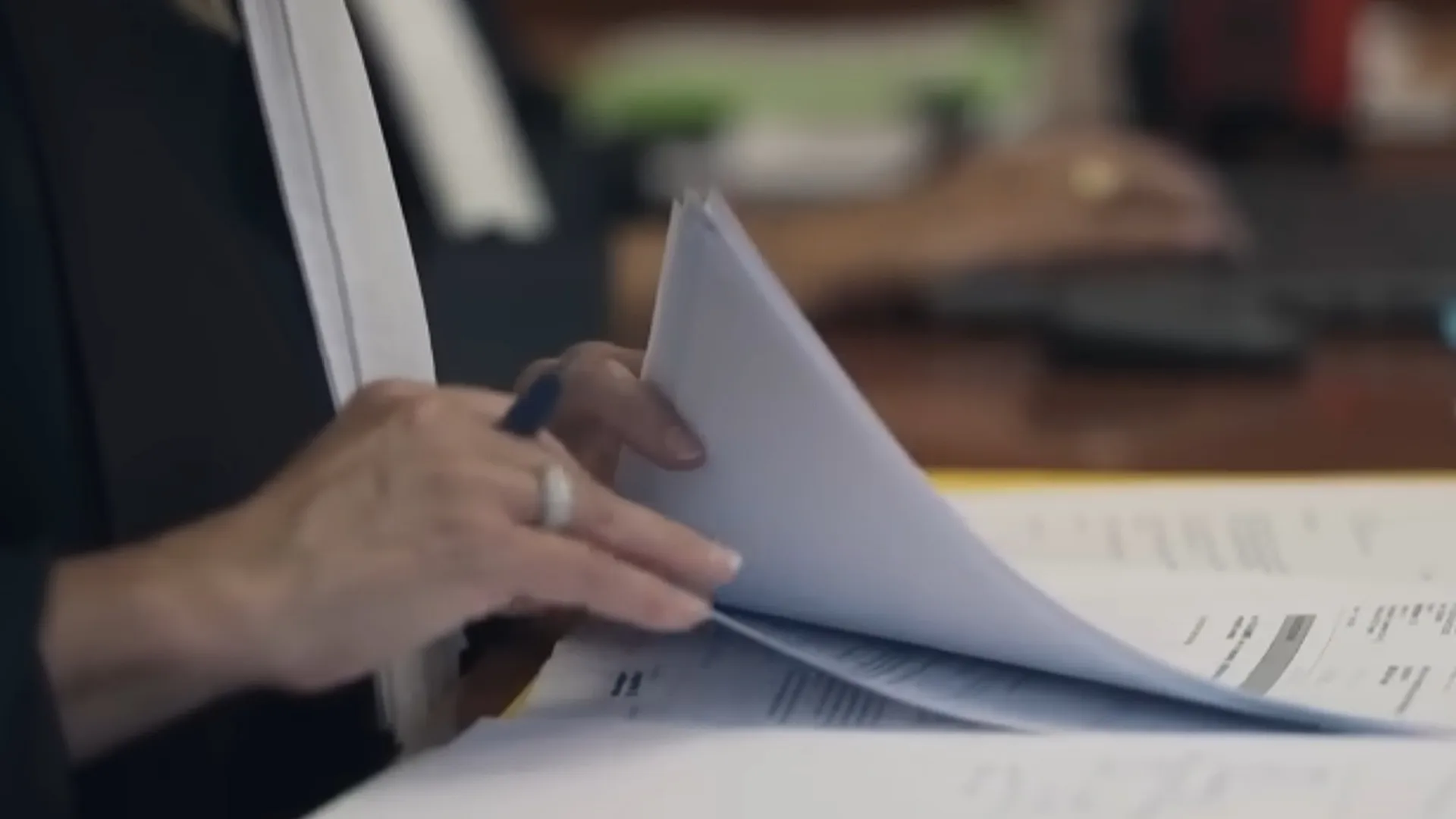 Handen bladeren door documenten in een rechtszaal