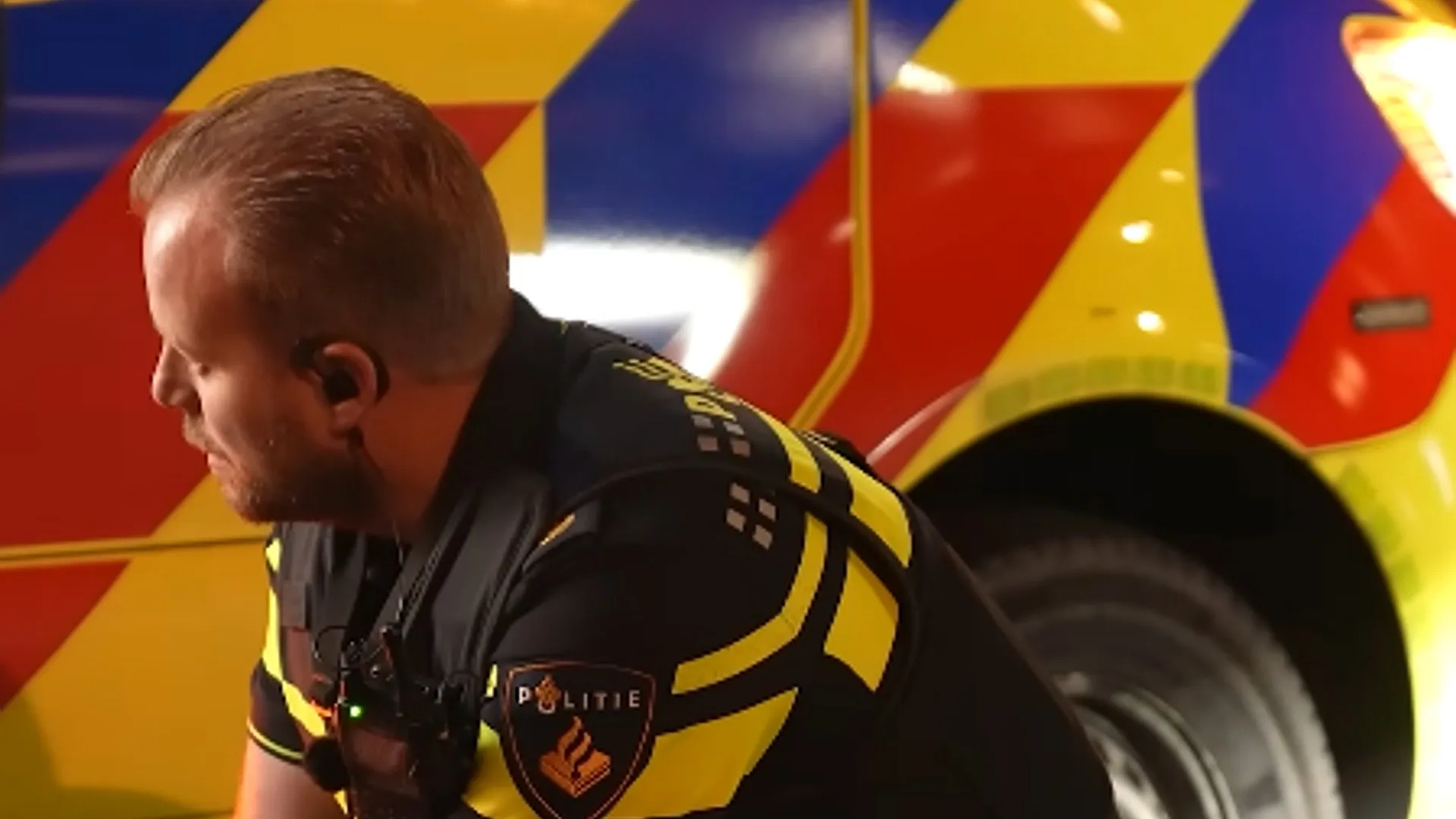 Politieagent bij een politievoertuig