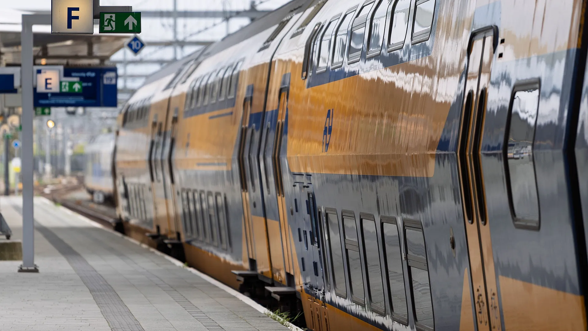 Gele trein bij een perron