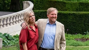 Koning Willem-Alexander en koningin Maxima lachend in een tuin