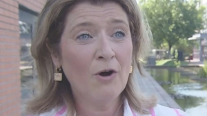 Josseline vertelt iets bij een gracht in de stad
