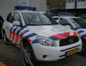 Nederlandse politieterreinwagen bij een gebouw