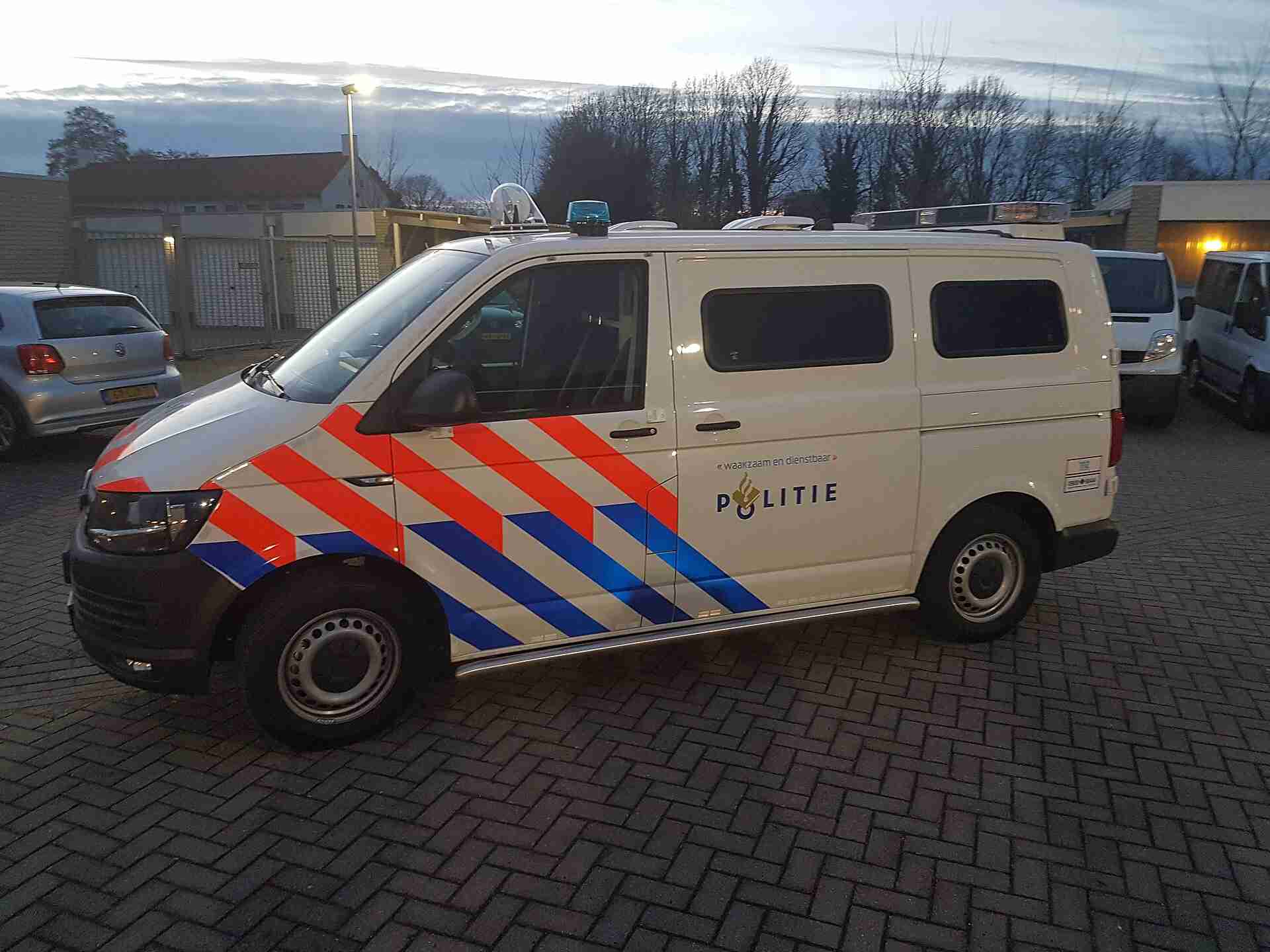 Leeg politiebusje geparkeerd langs een straat