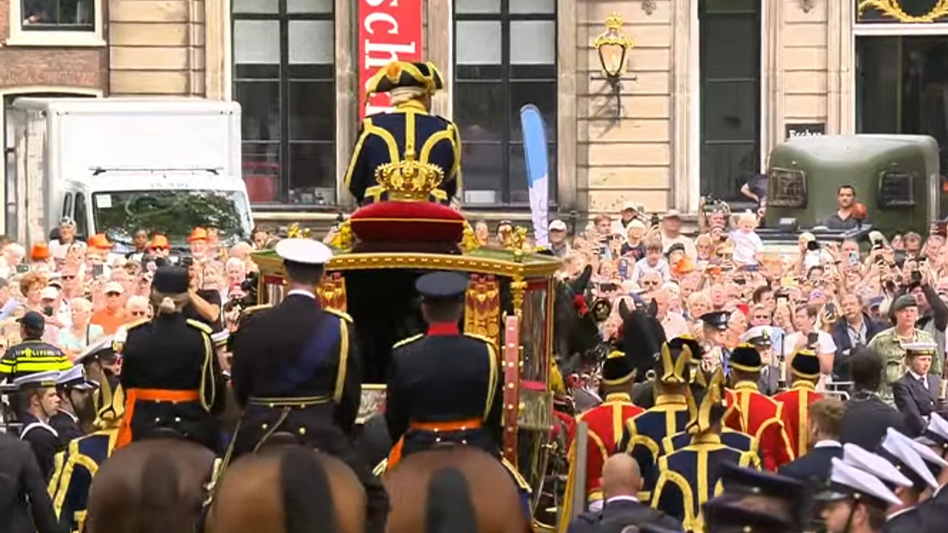 Koninklijk rijtuig met militairen en publiek in Den Haag