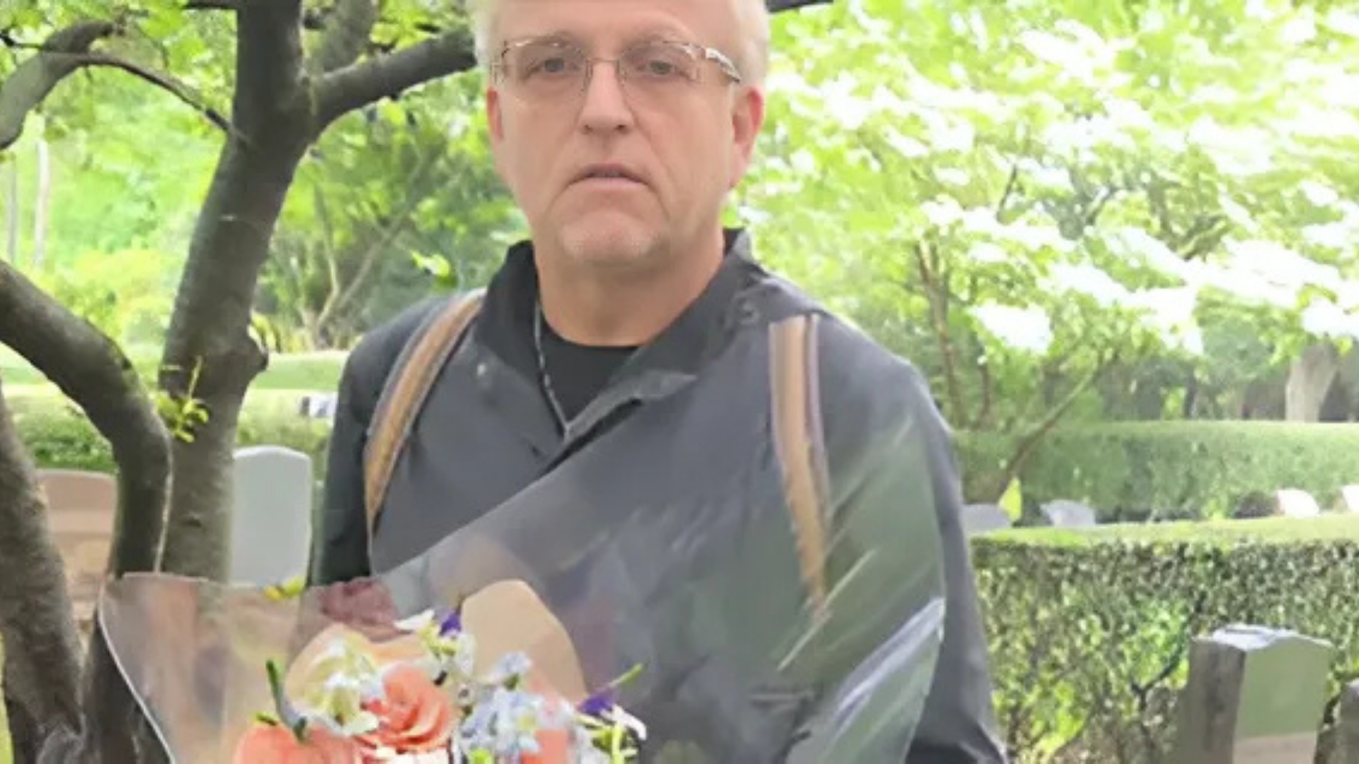 Gordon met een bos bloemen op een begraafplaats