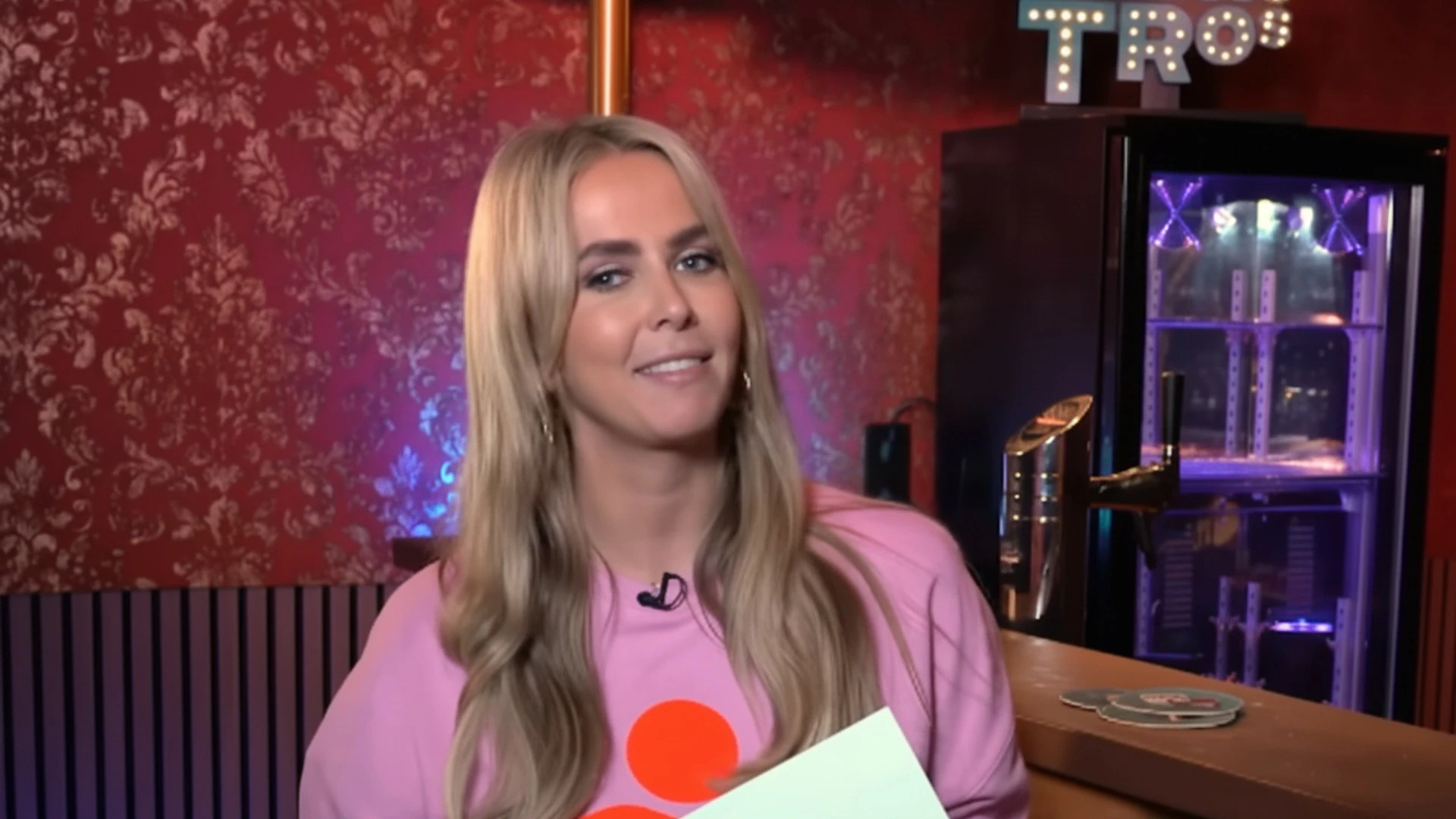 Monique Smit in het roze in een radiostudio
